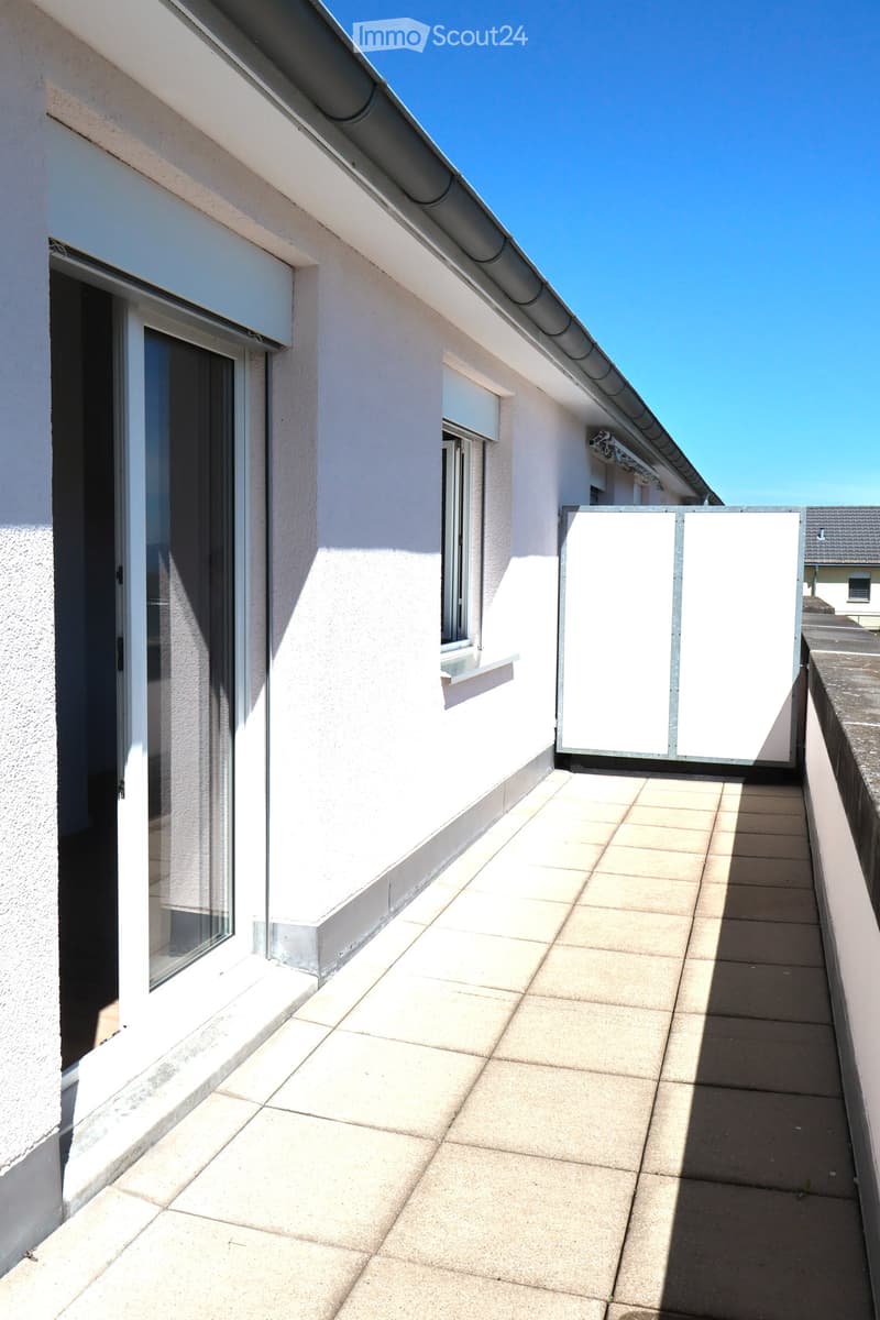 Balcony with tiled floor, white walls, sliding glass door, and a closed white privacy screen.