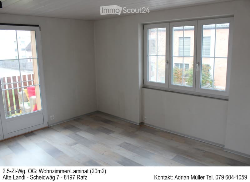Empty room with wooden flooring, large windows, and a sliding glass door leading to an outdoor area.