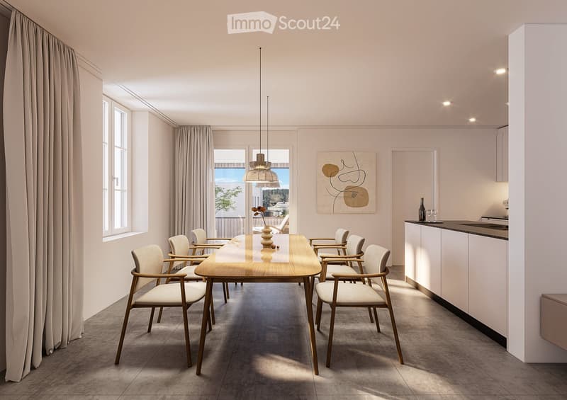 Modern dining area with a wooden dining table, six chairs, pendant light, and a small kitchen area with a counter, bottle, and cup. Large windows offer a view of the balcony and outdoor area.