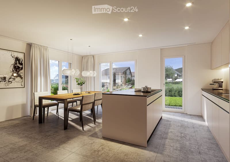 Modern kitchen and dining area with a central island, pendant lights, dining table with chairs, and large windows overlooking a green landscape.