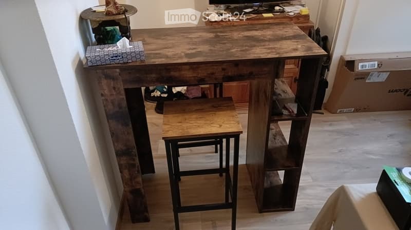 A wooden table with a tissue box on it, a small wooden stool, and a larger wooden stool with metal legs.