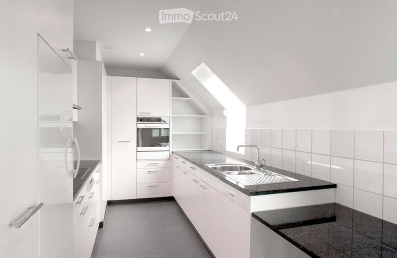 Modern, minimalist kitchen with white cabinets, a stainless steel sink, and a built-in oven. The space features a sleek, contemporary design with clean lines and ample storage.