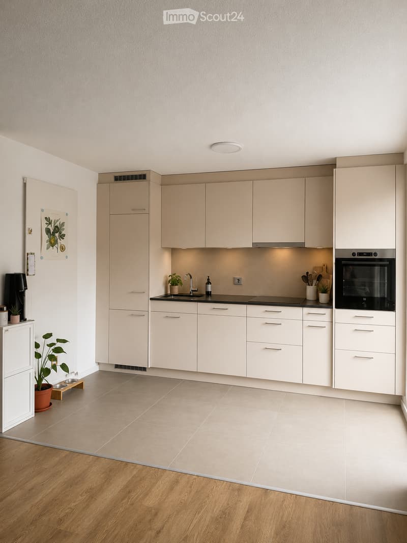 Modern kitchen with light-colored cabinets, stainless steel appliances, and a black countertop. Features include a sink, faucet, oven, and various kitchen utensils.