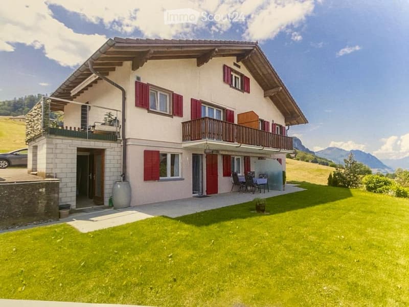 Two story house, red shutters, balcony, parking place, lawn, mountain view