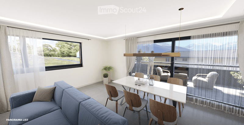 Modern living and dining area with a blue sofa, white dining table, wooden chairs, pendant light, and large windows with a scenic view.