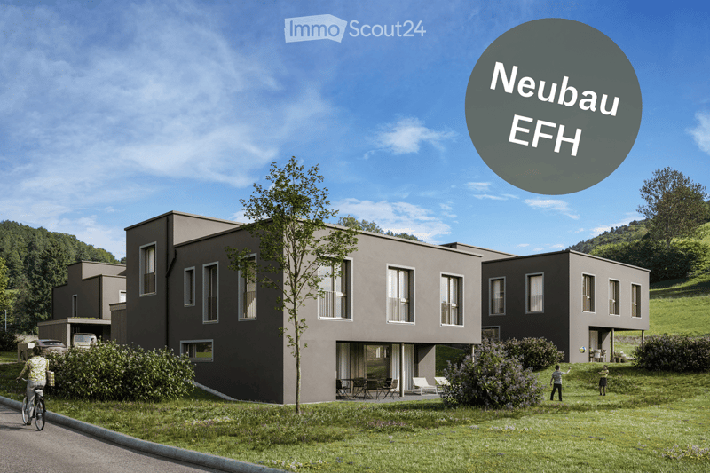 Modern two-story house with grey exterior, large windows, and a small garden area with outdoor seating.