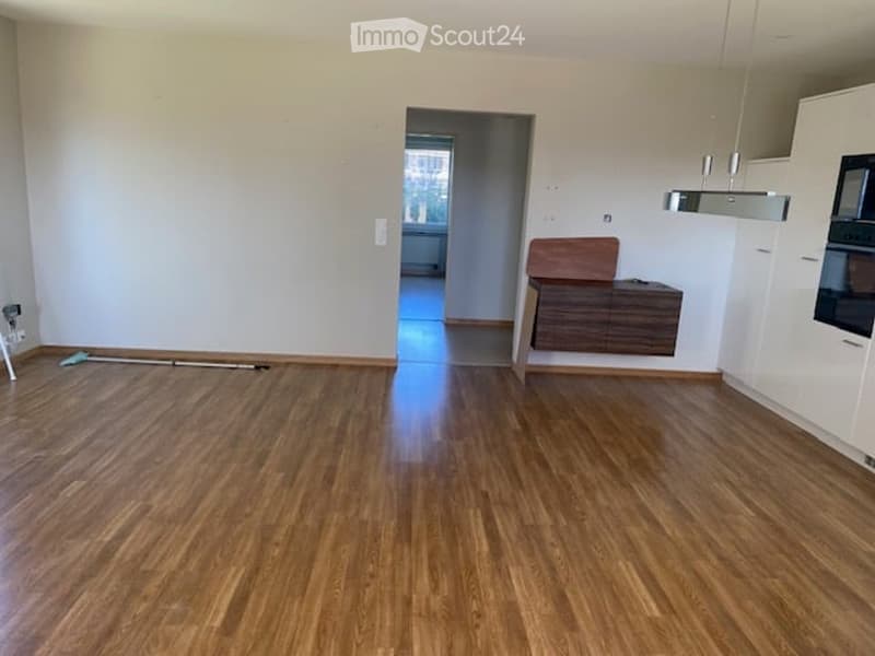 Empty room with wooden flooring, white walls, and a doorway leading to another room. No furniture or equipment is present.