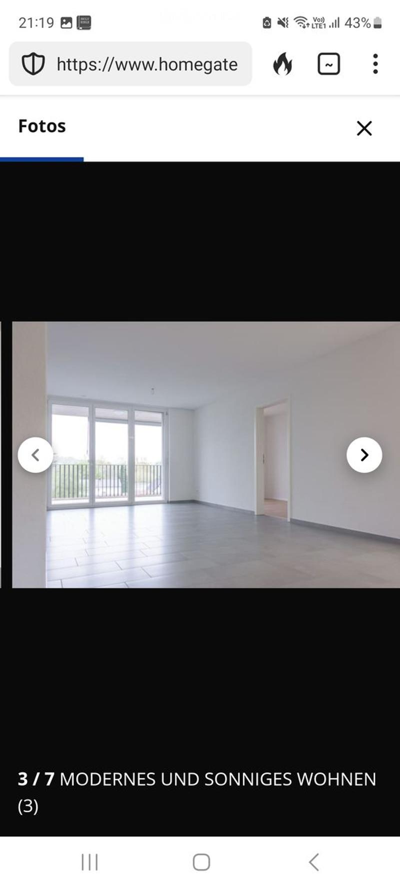 Empty room with tiled floor, white walls, large sliding glass doors leading to a balcony, and an open doorway to another room.