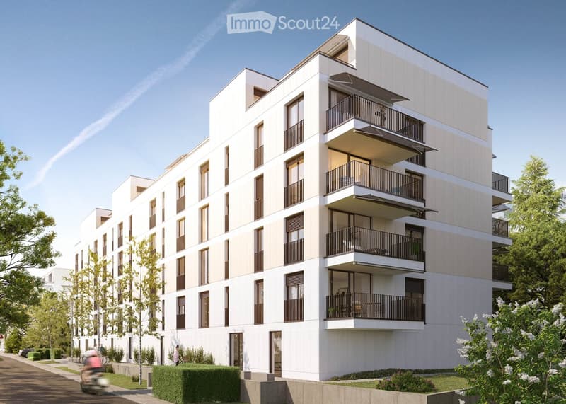 Modern multi-story residential building with balconies, large windows, and contemporary design. The building features a clean, minimalist facade with light-colored panels and dark window frames.