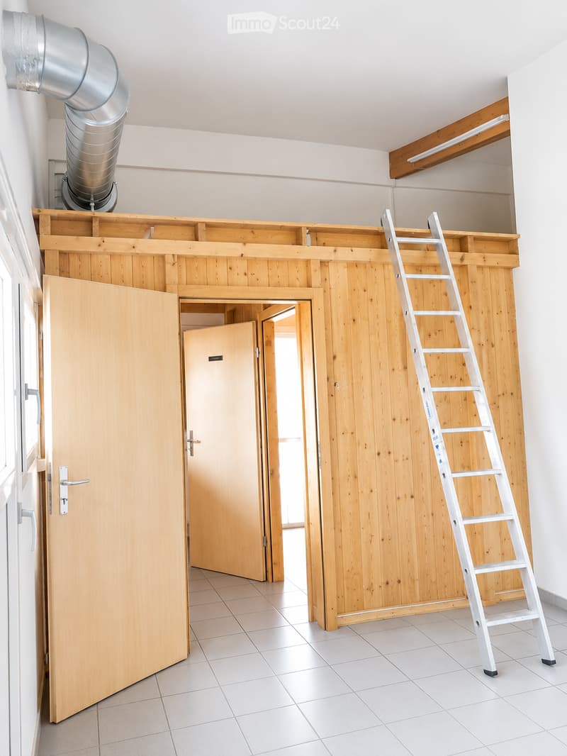 Empty room with white tiled floor, wooden walls, and a ladder leaning against the wall. There are two doors and a ventilation duct in the ceiling.