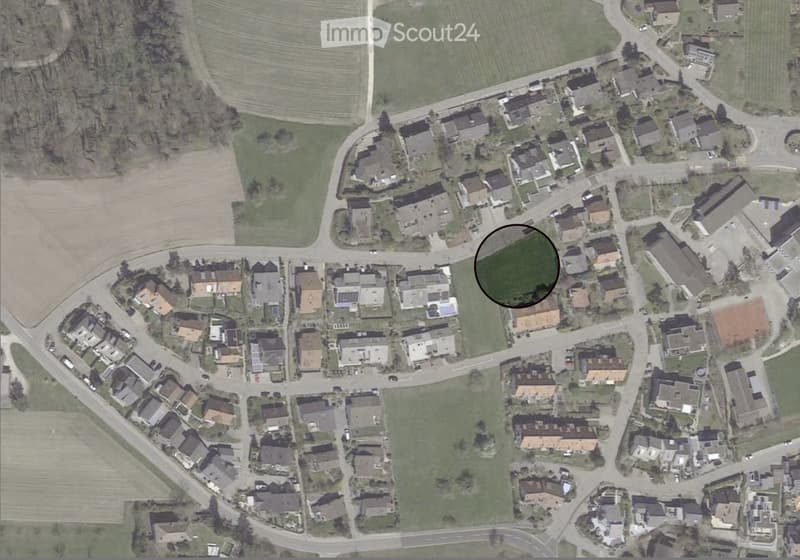 Suburban neighborhood with single family homes, some with solar panels, a playground, and roads.