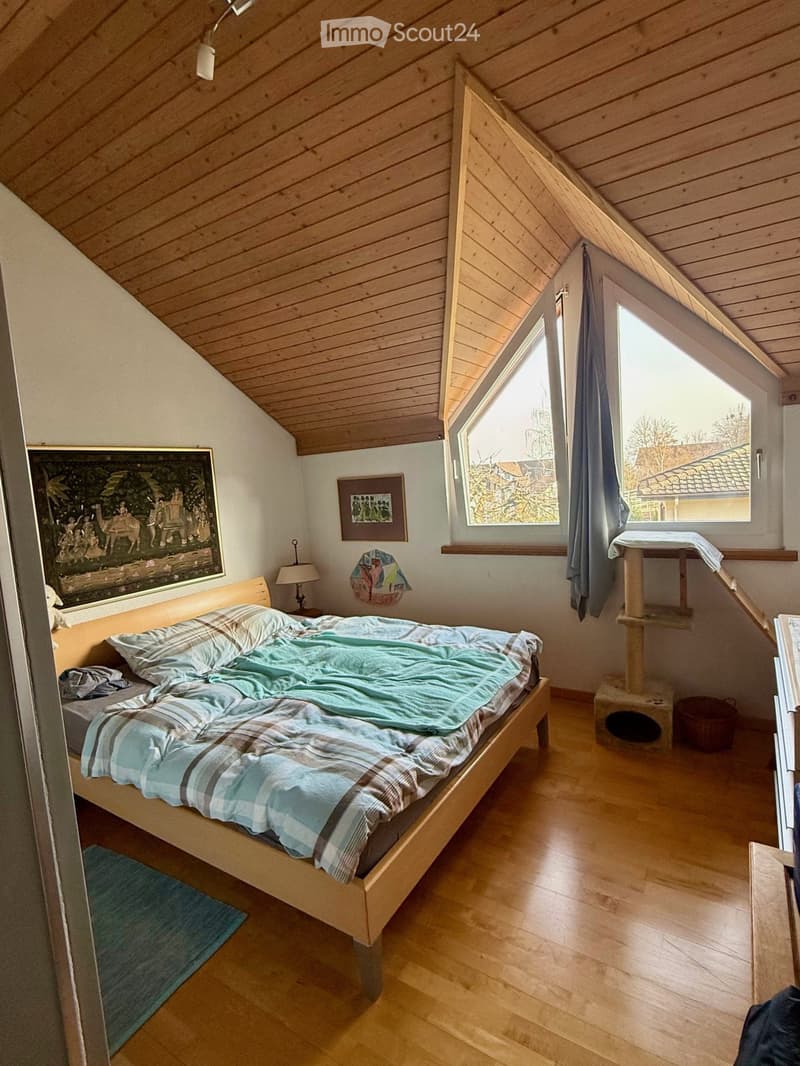 bedroom with wooden floor, bed, lamp, rug, cat tree, painting, window, wooden ceiling