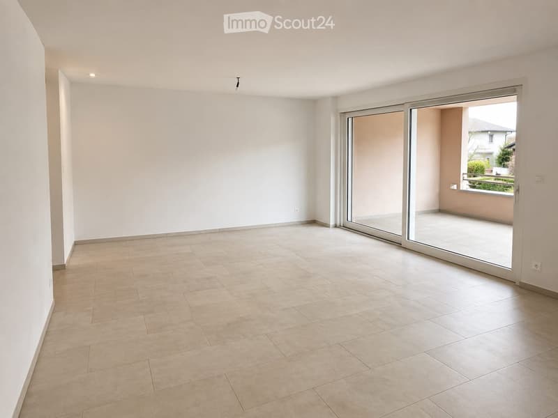 Empty room with tiled floor, white walls, and large sliding glass doors leading to a balcony.