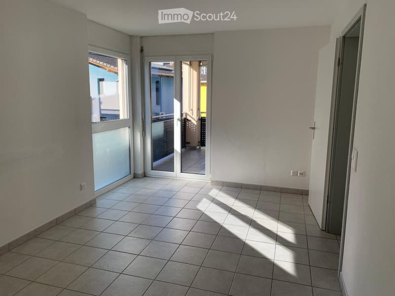 Empty room with tiled floor, white walls, and large windows. No furniture or equipment present.