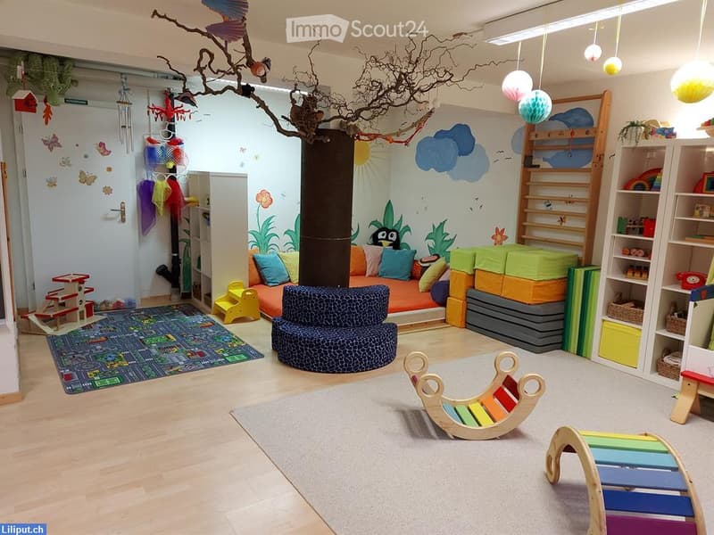 Brightly colored children's room with a tree trunk centerpiece, sofa, colorful pillows, toy blocks, rocking horse, and various play structures.