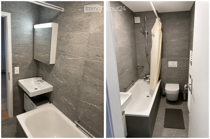 Modern bathroom with grey tiled walls, white fixtures including a sink, bathtub, and toilet, a built-in mirror cabinet, and a shower curtain.