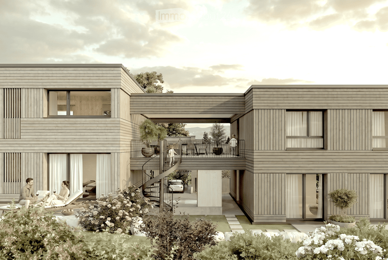 Modern two-story house with wooden siding, large windows, and a spacious balcony area. The ground floor features a lounge area with lounge chairs and a small garden, while the upper level includes a balcony with outdoor seating and a view of the surroundi