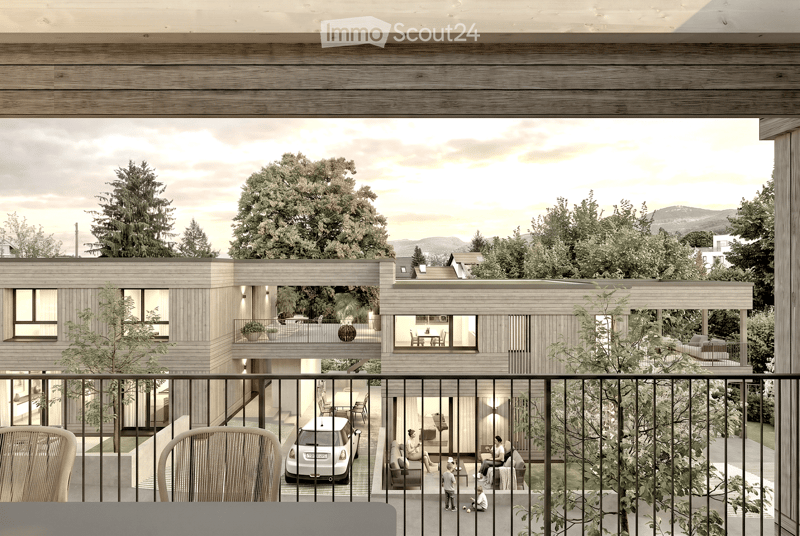 Modern two-story wooden house with large windows, balconies, and outdoor seating areas. The house features a contemporary design with a flat roof and is surrounded by trees and greenery. A car is parked in the driveway, and there are visible balconies wit