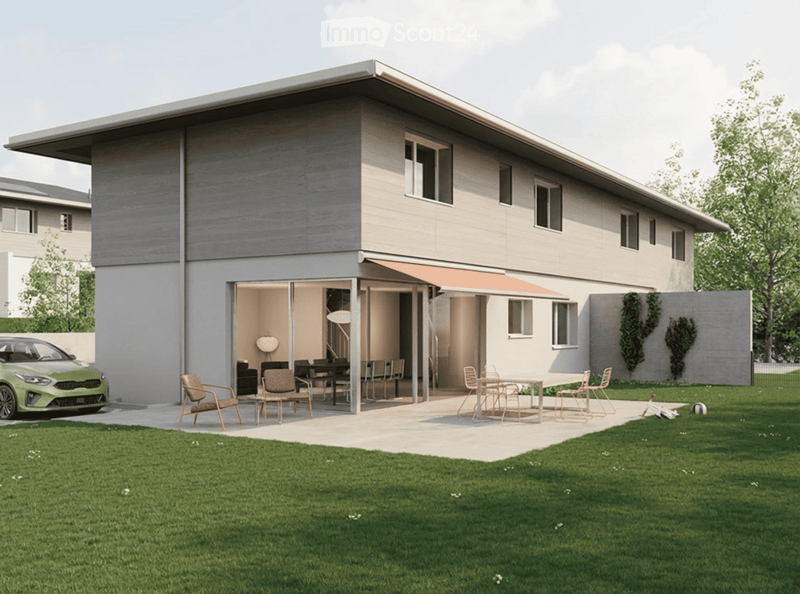 House. Modern two-story house with a flat roof, large windows, and an open patio area with outdoor furniture. A green car is parked nearby, and the surrounding area includes a well-maintained lawn and trees.