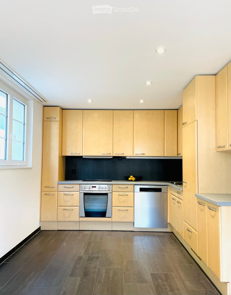 modern kitchen with wooden cabinets, stainless steel appliances, tiled floor, window