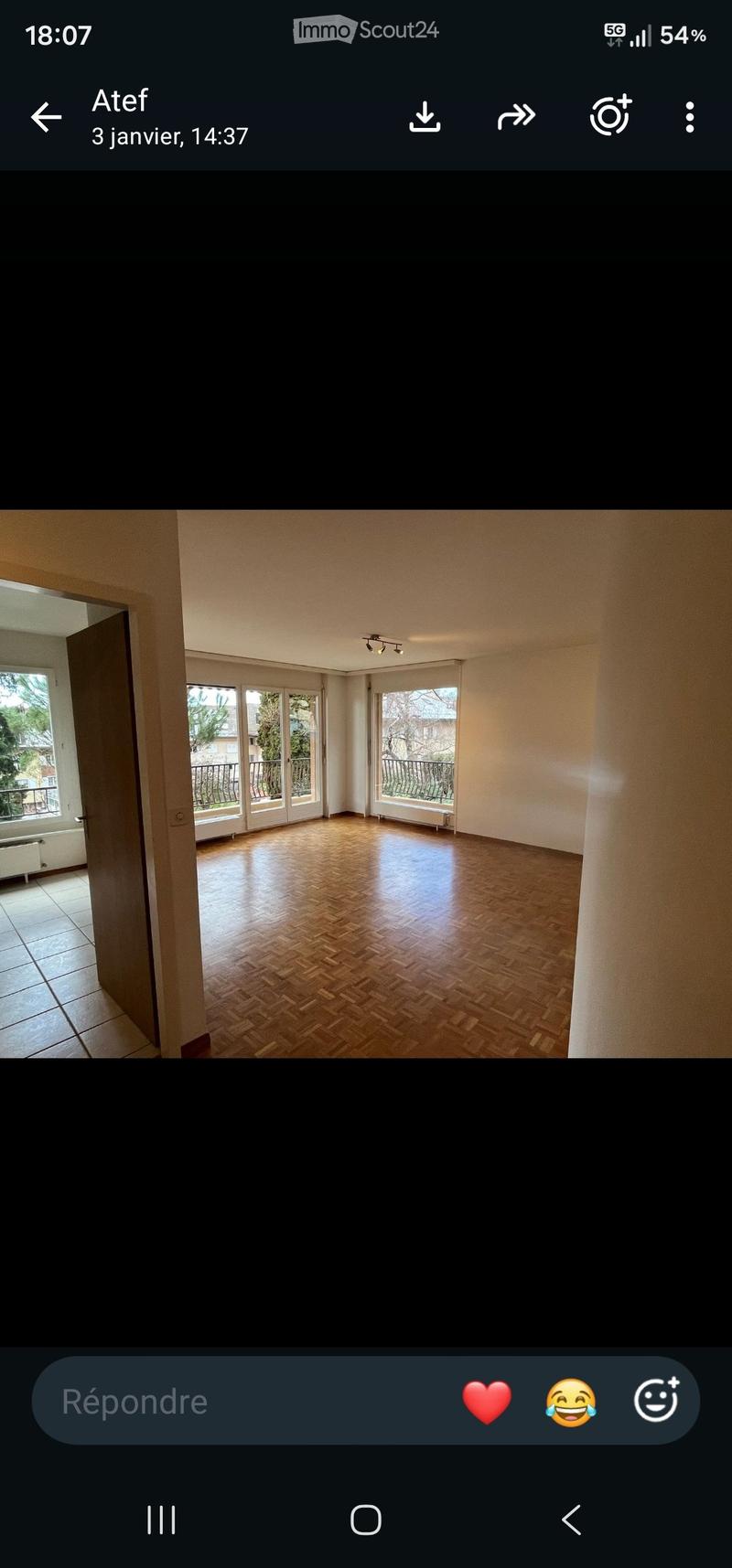Empty room with wooden flooring, large windows, and access to a balcony.