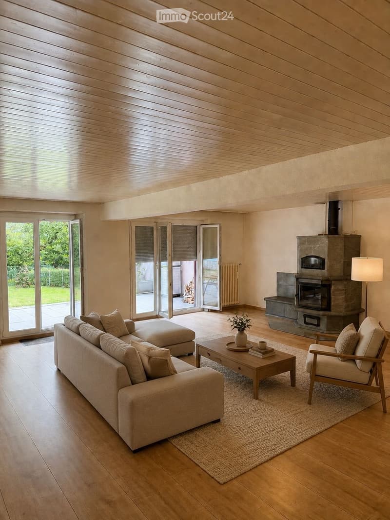 Modern living room with wooden floors, a fireplace, large windows, and a sofa, coffee table, and armchair.