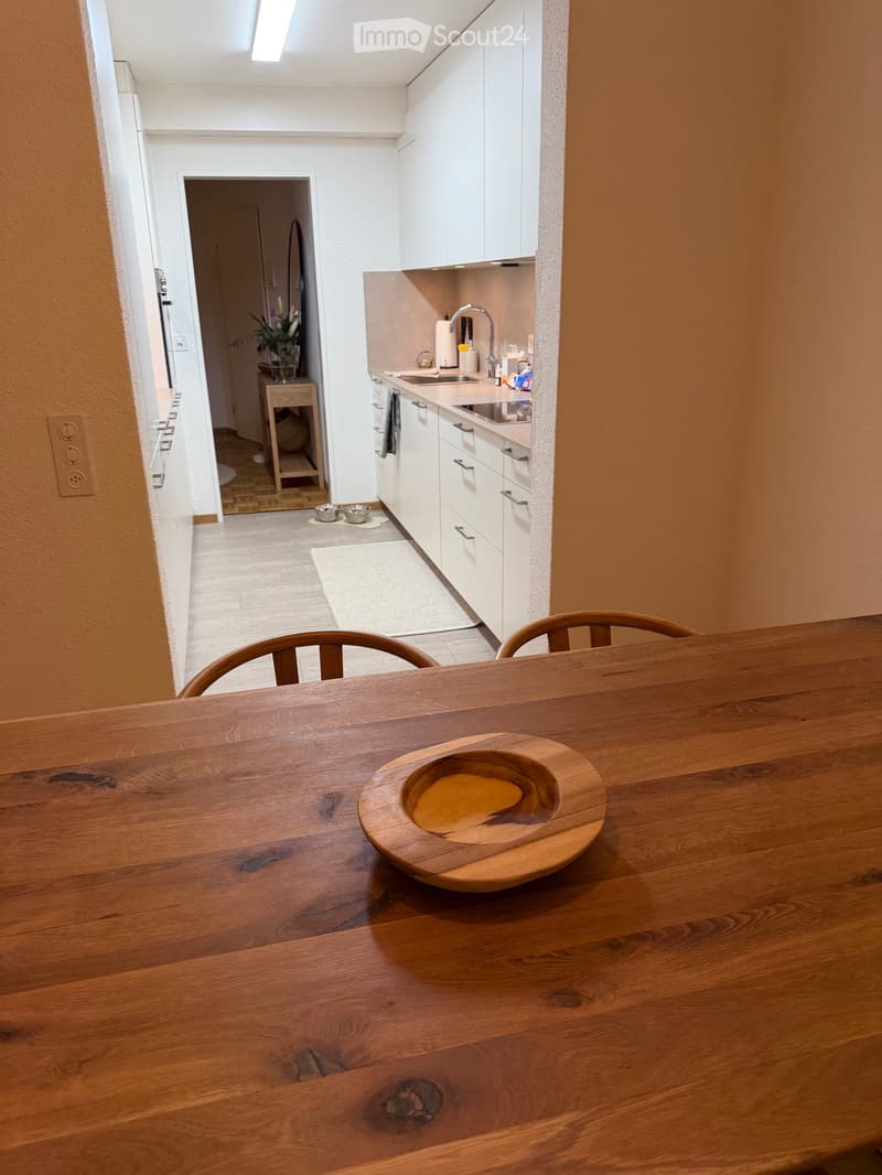 white cabinets, wooden floor, countertop, stainless steel sink, faucet, bowl, dining table