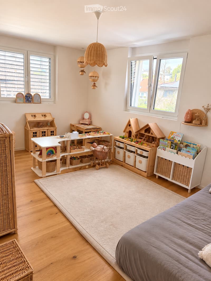 Bright, cozy bedroom with a bed, wooden shelves, toy furniture, and a variety of children's toys. Features large windows, a hanging wicker lamp, and a soft white rug.