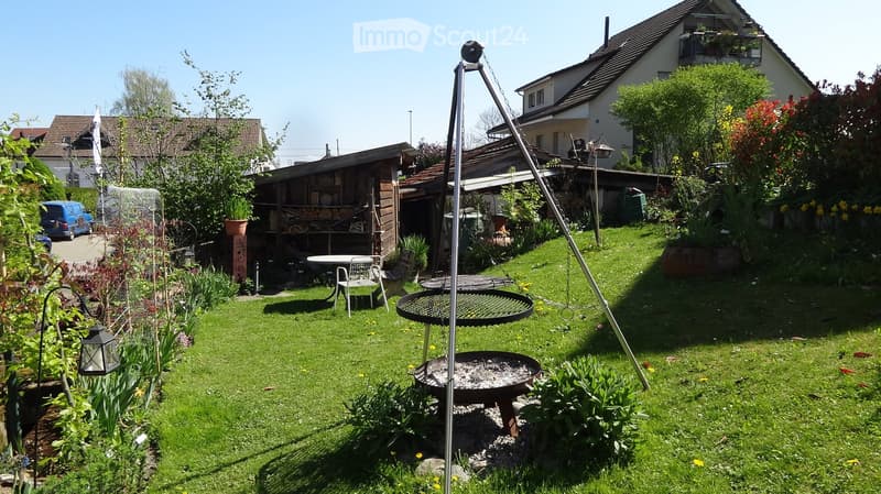 Garden / Outdoor Area. Well-maintained garden with a barbecue, seating area, and surrounding greenery.