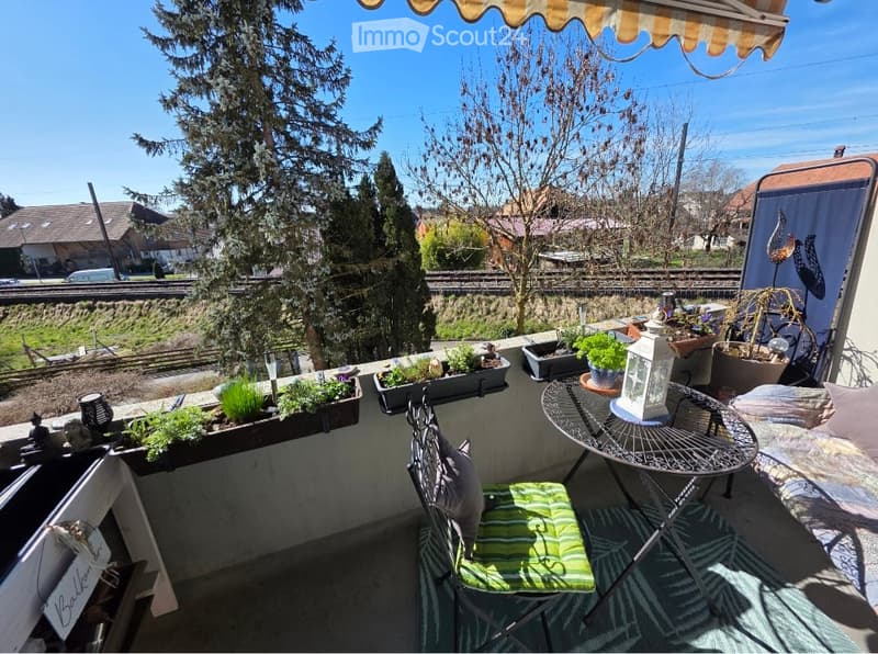 Balcony with outdoor furniture, potted plants, and a view of the surrounding area.