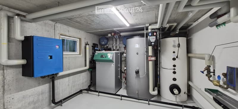 Utility room with water heaters, boiler, control panel, and various pipes.
