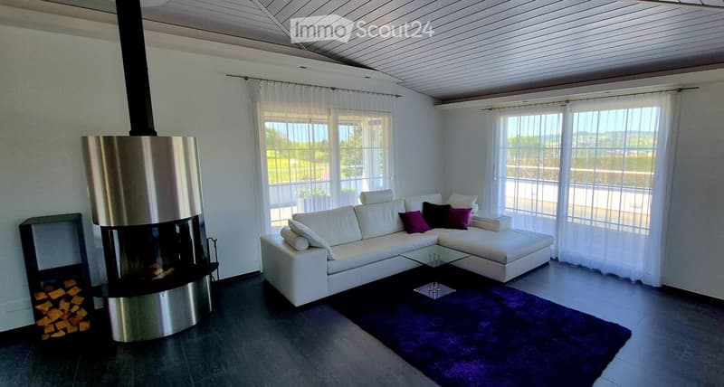 Modern living room with white sectional sofa, purple throw pillows, glass coffee table, purple shag rug, and a sleek stainless steel fireplace.