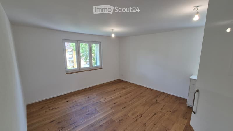 Empty room with wooden flooring, white walls, and a window with three panes. No furniture or equipment is present.