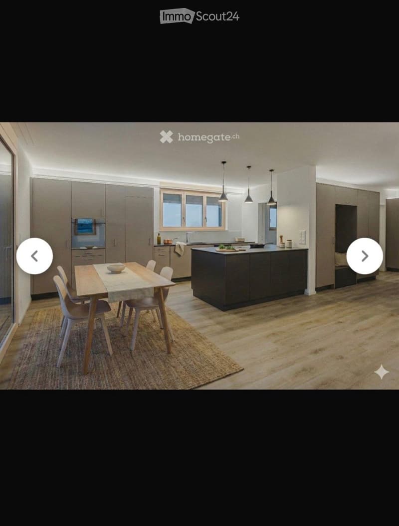 Modern kitchen with a central island, dining table, and chairs, featuring built-in cabinets and appliances.