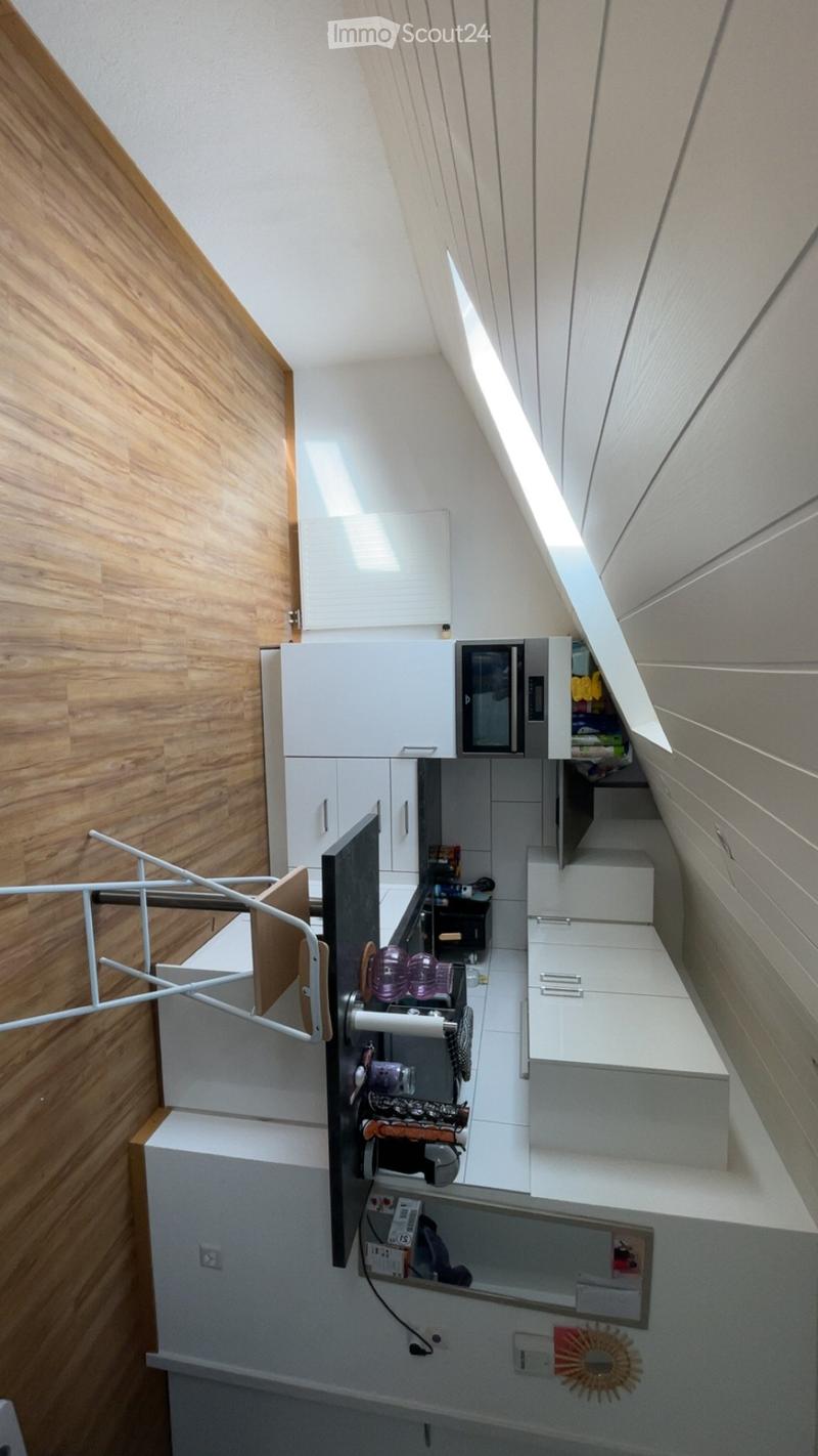 Compact kitchen with white cabinets, microwave, sink, and decorative items on the counter.