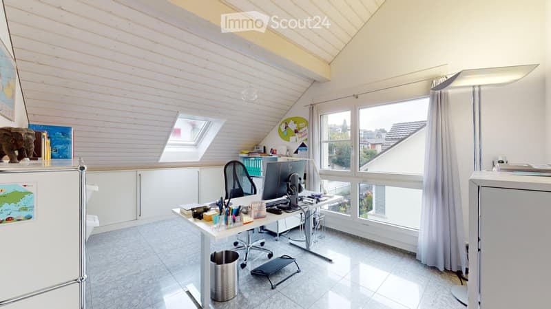 Bright, modern office space with wooden walls, large windows, and skylight. Features a desk with computer, chair, and various office supplies. Includes a cabinet, floor lamp, and decorative items like a map and statue.