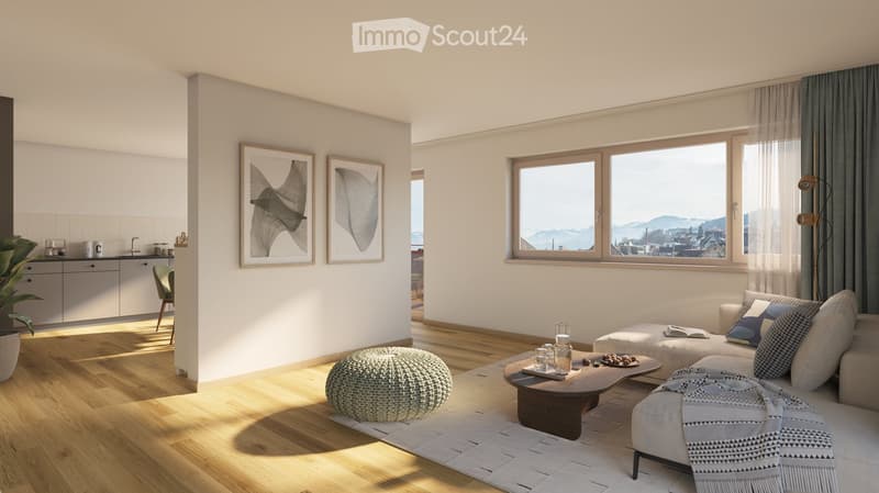 Modern living room with large windows offering a scenic view, featuring a white sofa with patterned cushions, a wooden coffee table, a round ottoman, a cozy stool, a kitchen area with cabinets, and framed artwork on the wall.