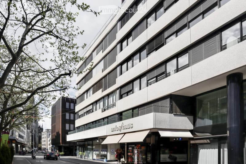 Modern multi-story building with large windows and a sign reading "antifhaus" on the ground floor.