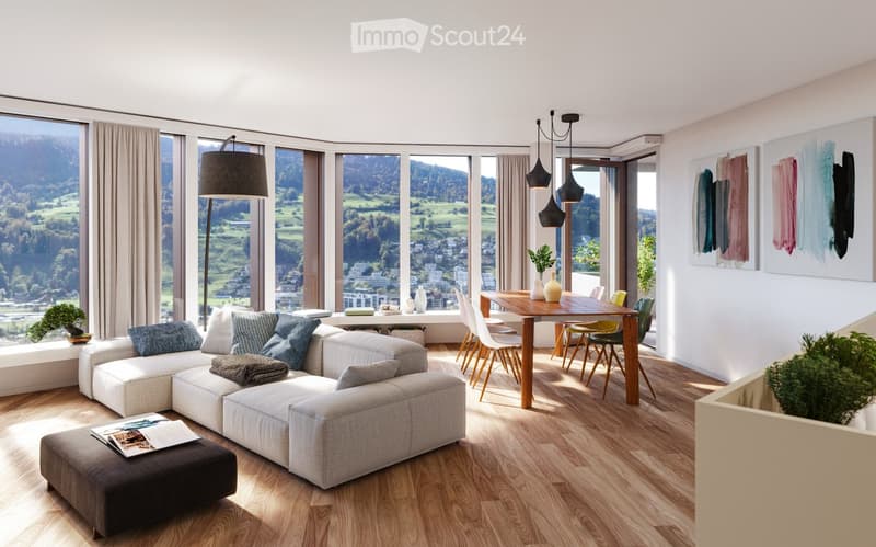 Modern living and dining area with large windows offering scenic views, a sectional sofa, dining table, chairs, and decorative items.