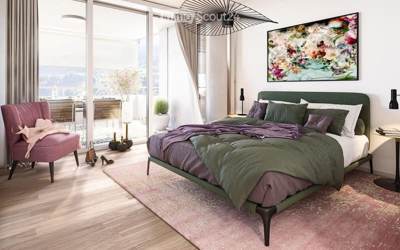 Modern bedroom with a large bed, green headboard, pink armchair, side table, and a scenic view through large windows.