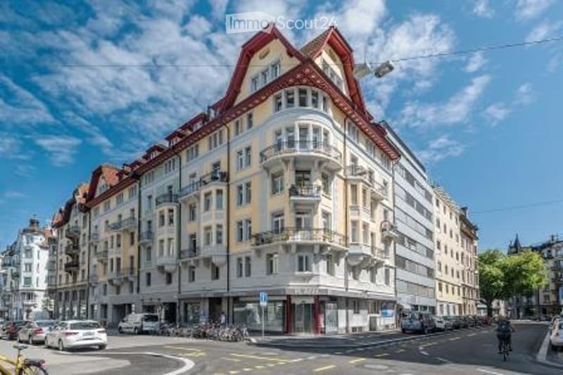 Multi-story residential building with balconies, ornate facade, and classic architectural details.