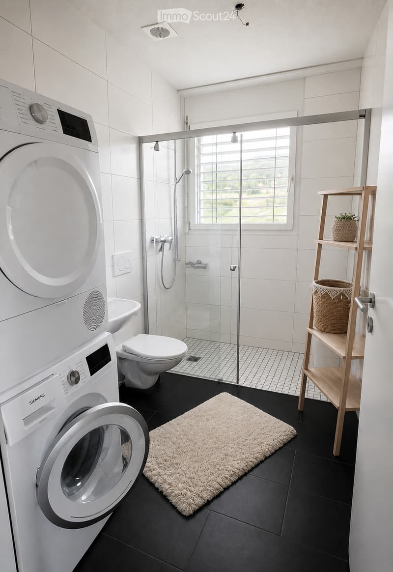 Modern bathroom with white tiles, black floor, washing machine, toilet, sink, glass-enclosed shower, wooden shelf with baskets, and a white shag rug.