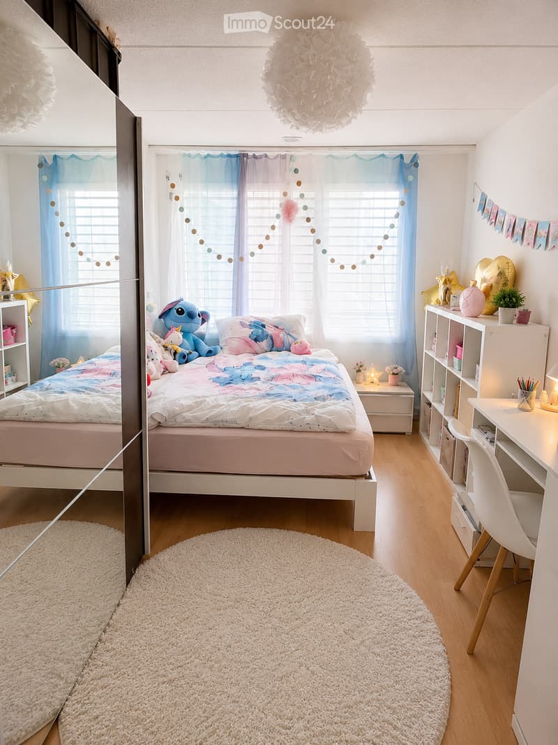 A well-lit bedroom with a bed, nightstand, desk, chair, shelf, and decorative items including a balloon and a potted plant. The room features a round white rug, colorful curtains, and a decorative string light garland.