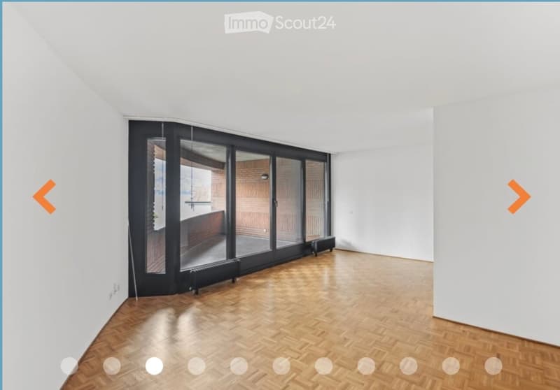 Completely empty room with wooden floor and large glass sliding doors leading to a balcony area.