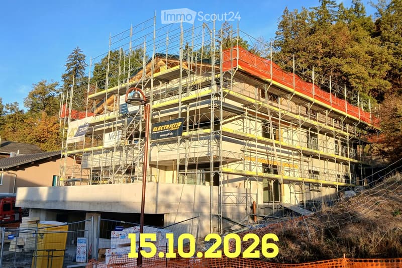 A multi-story building under construction, covered in scaffolding with visible signage and a partially constructed facade.