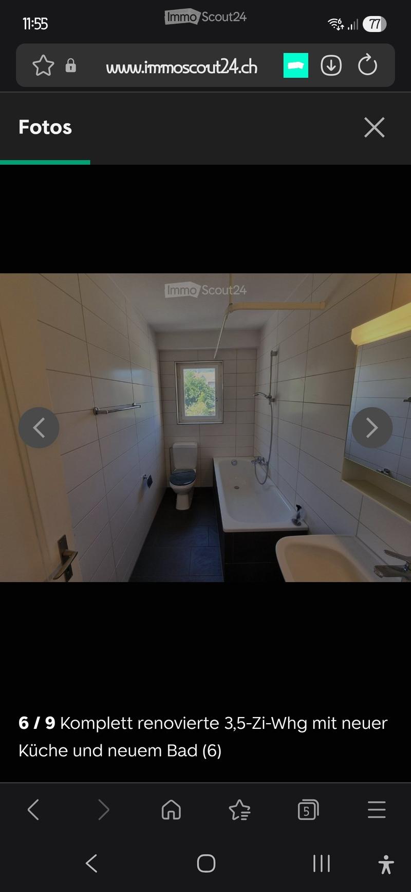 Modern bathroom with white tiled walls, a toilet, a bathtub, a sink, and a mirror. The room has a window providing natural light.