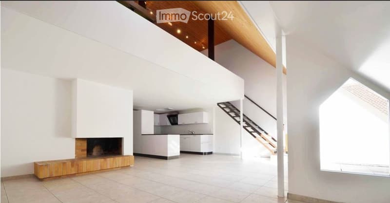 Open-plan living and kitchen area with white walls, a fireplace, a bench, and a staircase leading to an upper level.