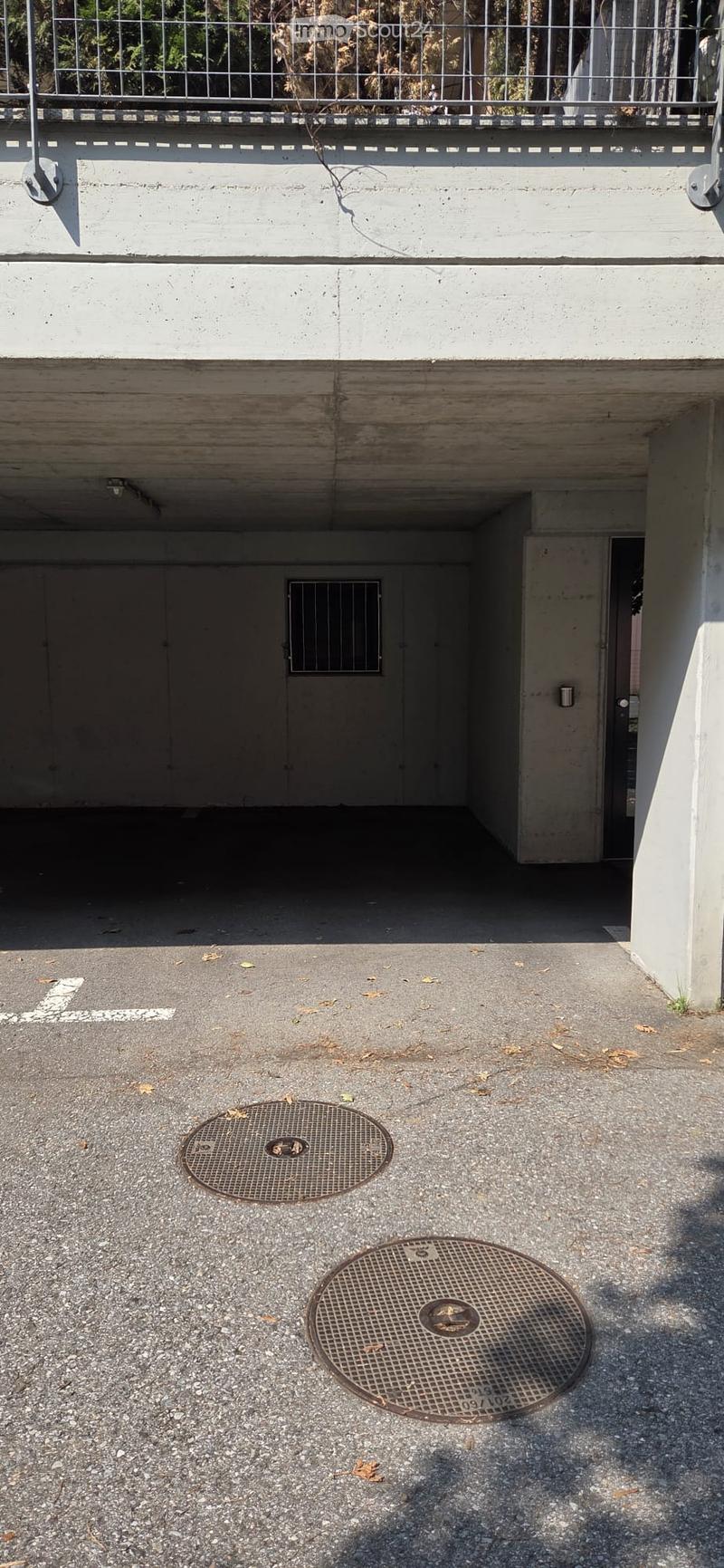 {"type": "Garage", "objects": [], "description": "Underground parking area with concrete floors, metal doors, and two manhole covers on the ground.", "localized_descriptions": {"EN": "Underground parking area with concrete floors, metal doors, and two man