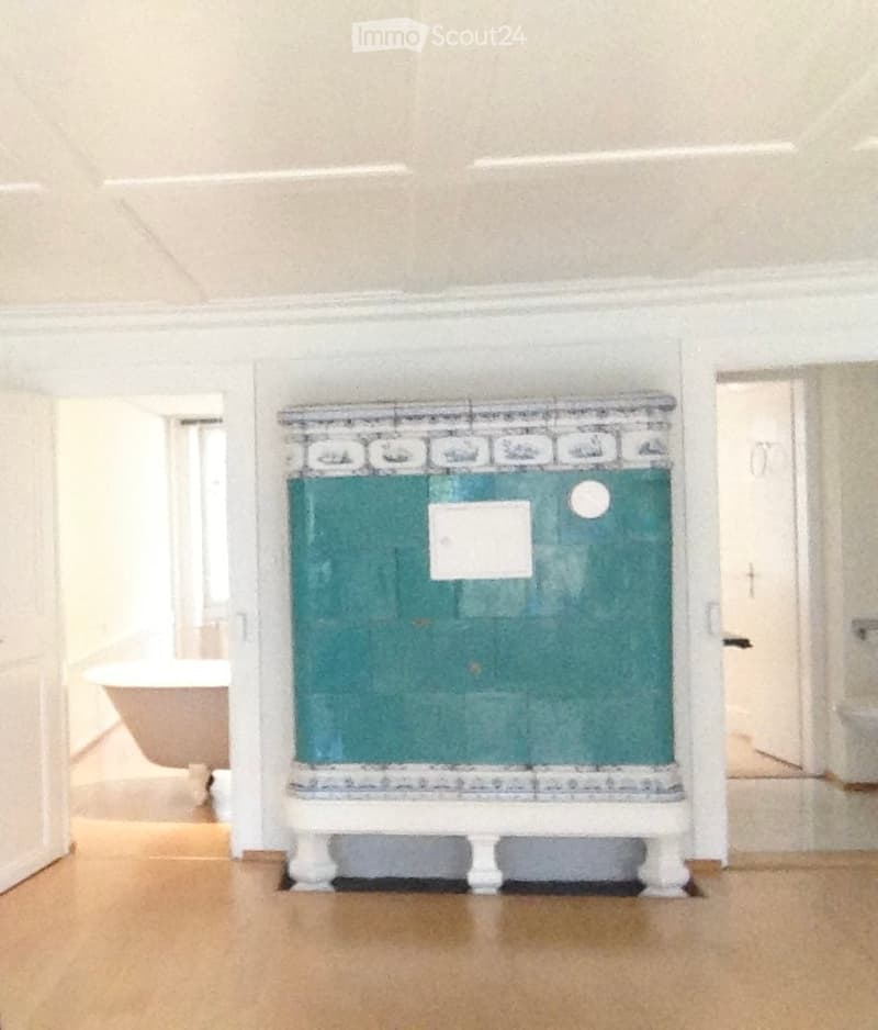 Bathroom with a bathtub, toilet, and a decorative green cabinet with a tiled top.