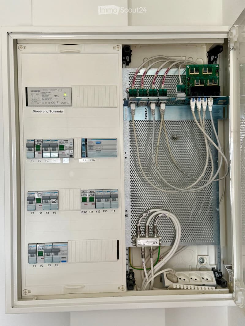 Electrical panel with multiple circuit breakers, wiring, and a circuit board inside an open panel box.